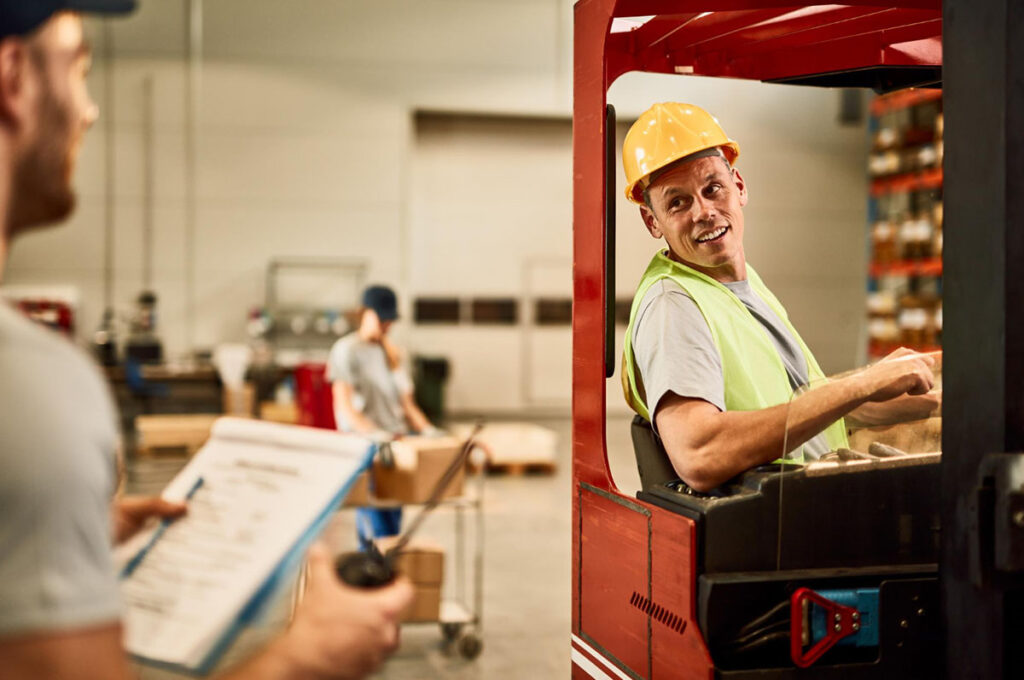 Forklift operator talking to foreman at the warehouse