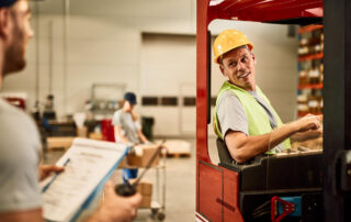 Forklift operator talking to foreman at the warehouse